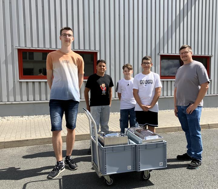 „genialsozial" 2025 in Wurzen: Auf dem Bild sieht man 4 Schüler, die einen Mitarbeiter von Griesson - de Beukelaer bei seinen täglichen Arbeiten in der Produktion unterstützten 